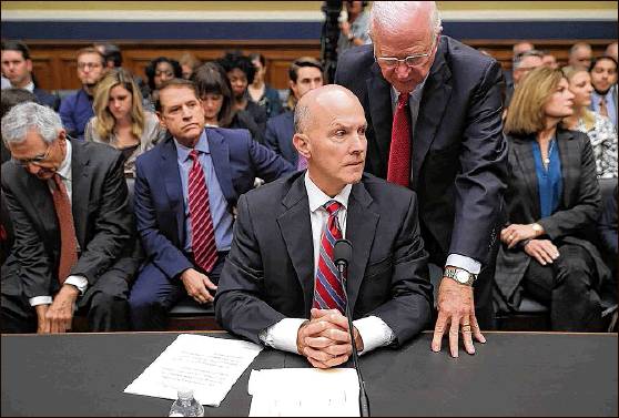 Former Sen. Saxby Chambliss, R-Georgia, advises former Equifax CEO Rick Smith before Smith testifies to the House Energy and Commerce Committee’s Digital Commerce and Consumer Protection Subcommittee on Capitol Hill last fall. Smith stepped down as CEO of Equifax after hackers broke into the agency. GETTY IMAGES